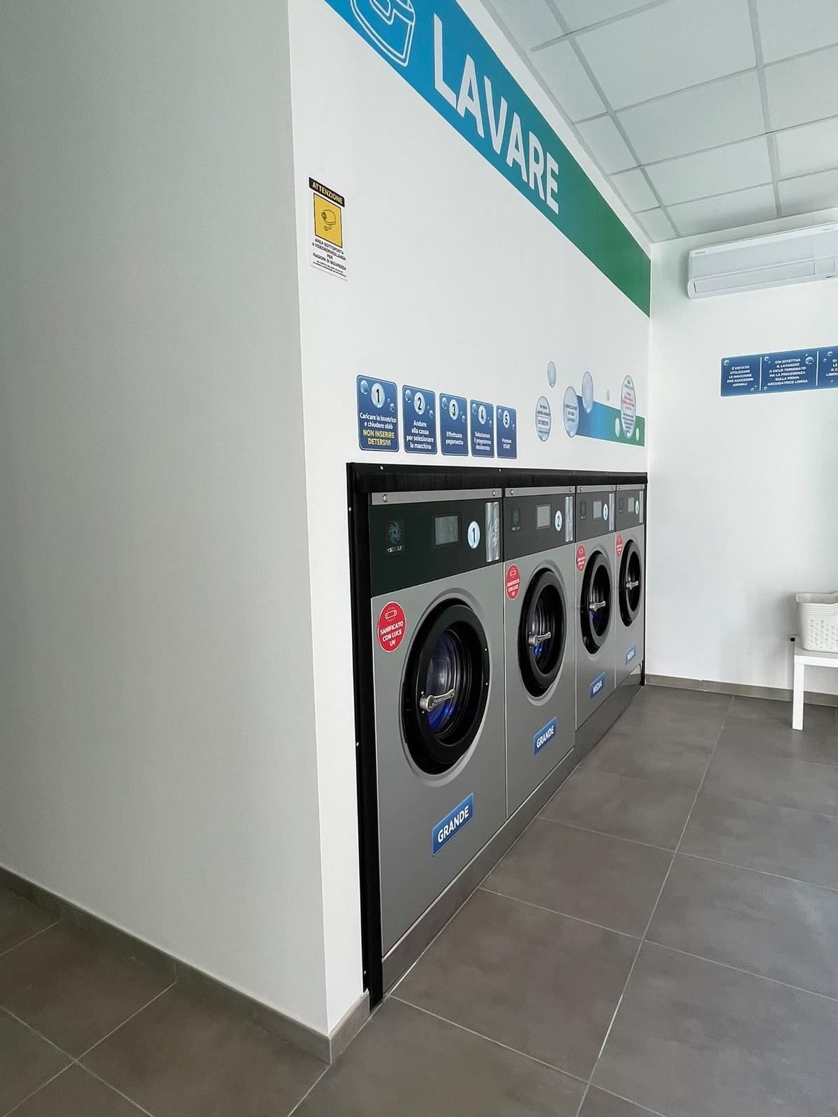 Lavatrici con sanificazione UV a luce blu nella lavanderia Acqua Sapone